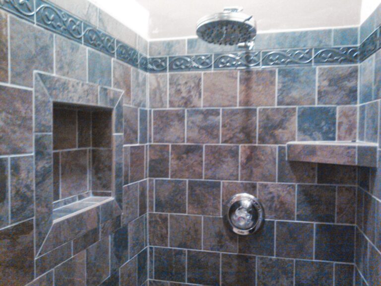 Custom tiled shower with built-in niche, corner shelf, and decorative tile border, installed by Thaxton Construction in Griffin, GA