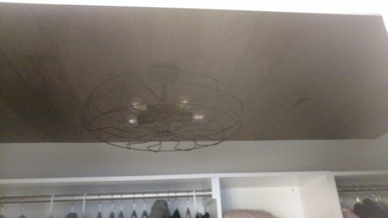 Custom closet ceiling with dark wood paneling and a vintage-style caged ceiling light fixture, completed by Thaxton Construction in Griffin, GA