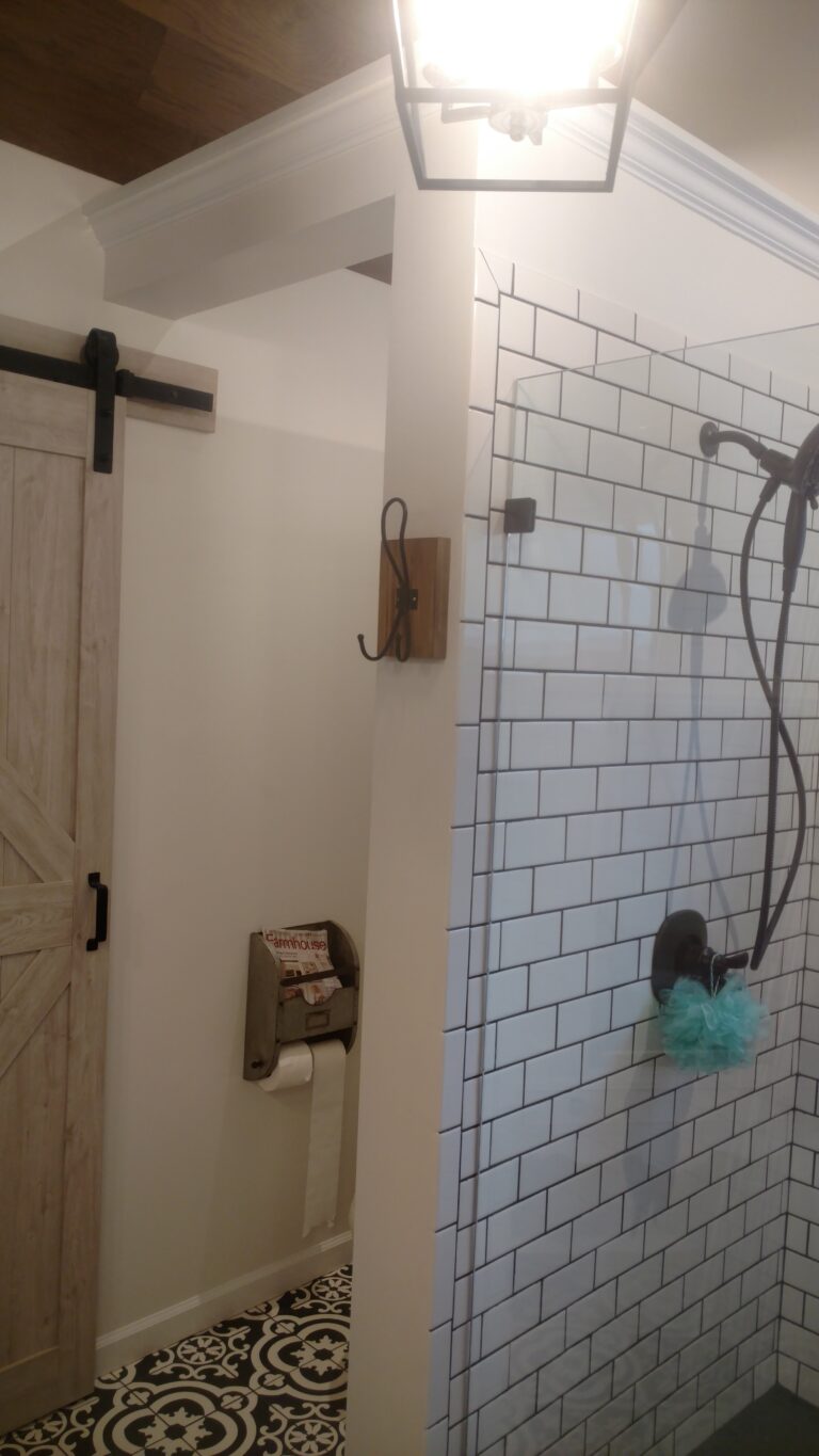 A white tiled bathroom with a new ceiling light installed
