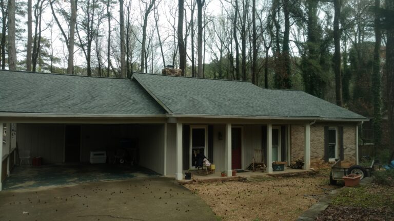 A single-story house with a prominent, dark gray asphalt shingle roof