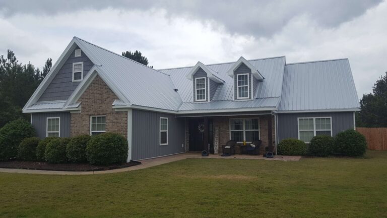 modern single-family home with a prominent gray metal roof and light gray siding
