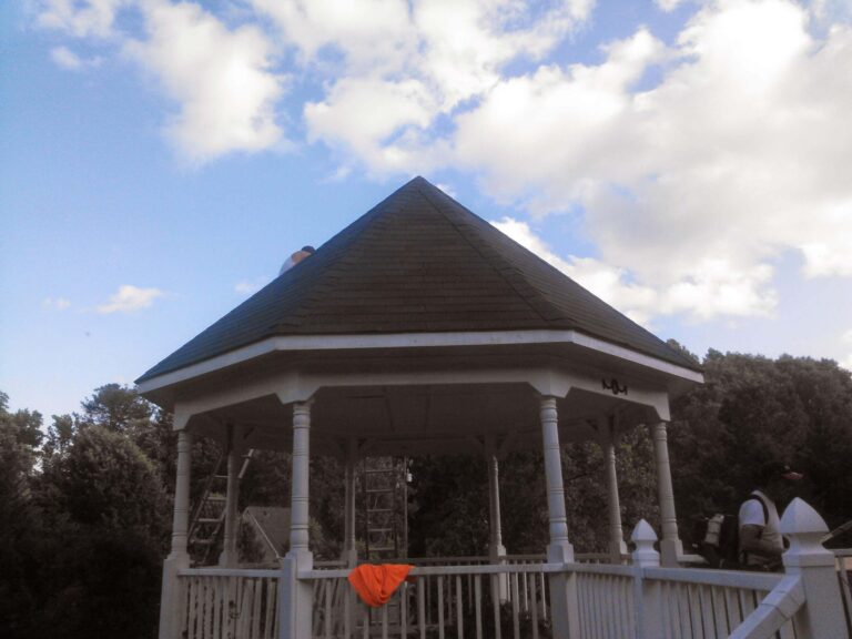 A white gazebo with a newly installed dark asphalt shingle roof