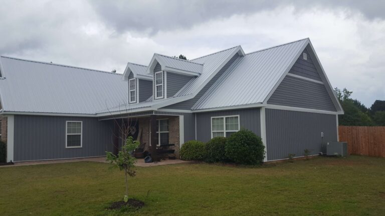 A modern house with a gray metal roof and gray siding