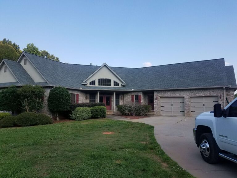 large residential house with a dark gray aspjhalt shingle roof