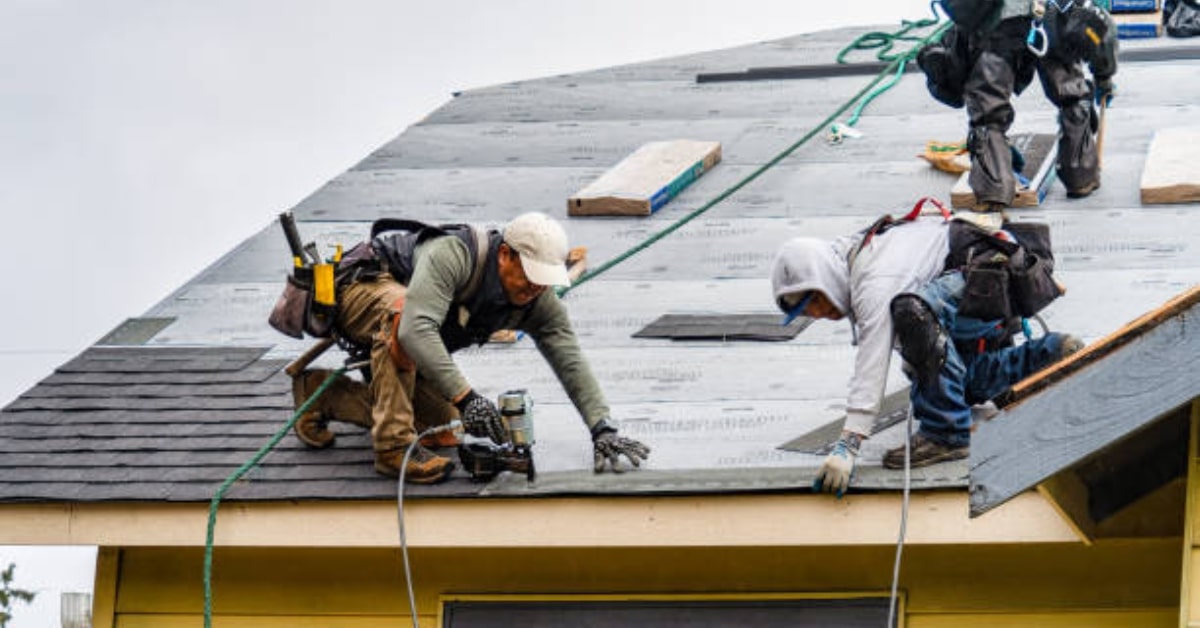 roofing company workers working on repairing a residential roof